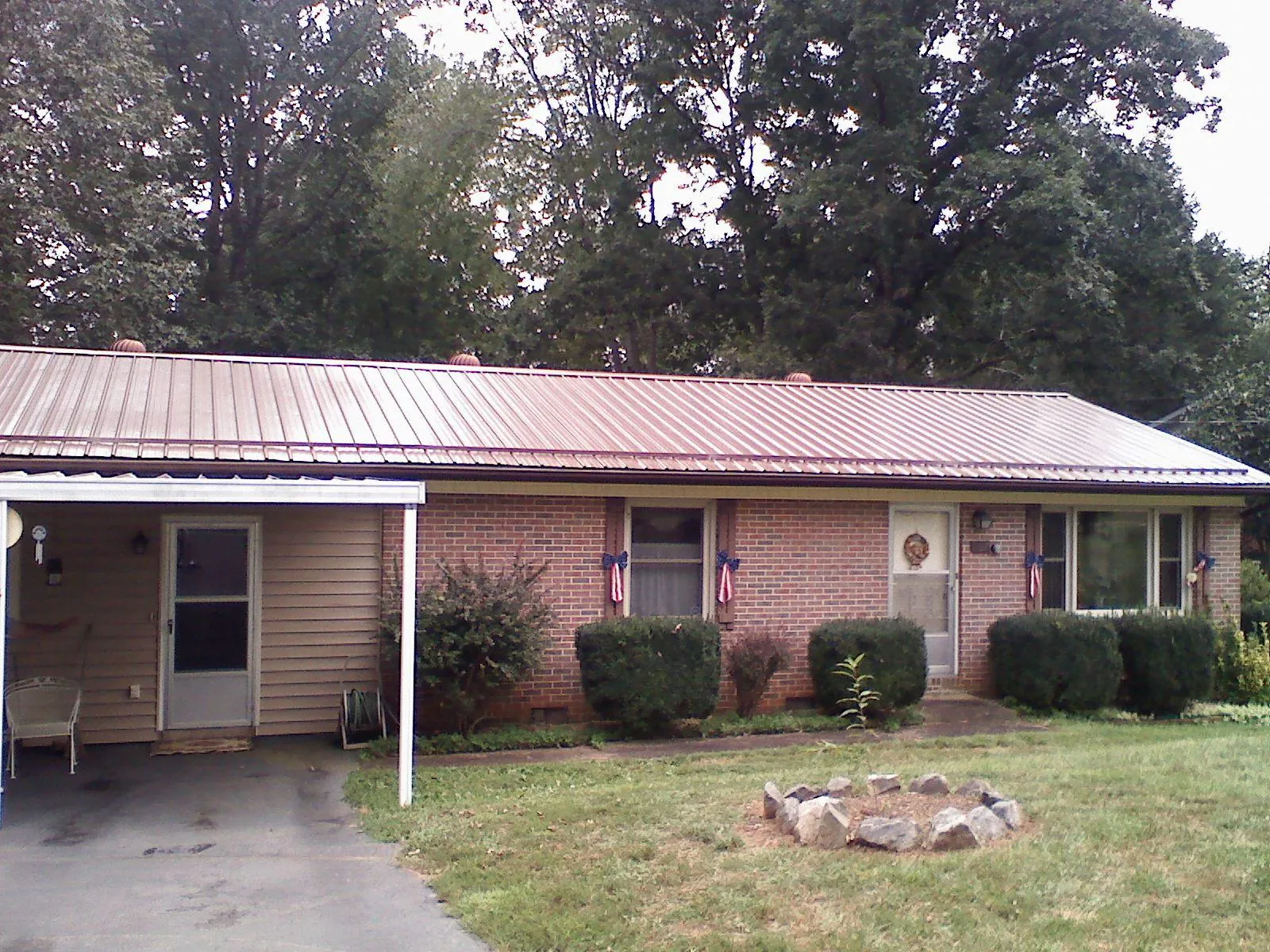 Bronze metal roof and carport on a brick ranch home — Roof Repair work by our crew in Emmett